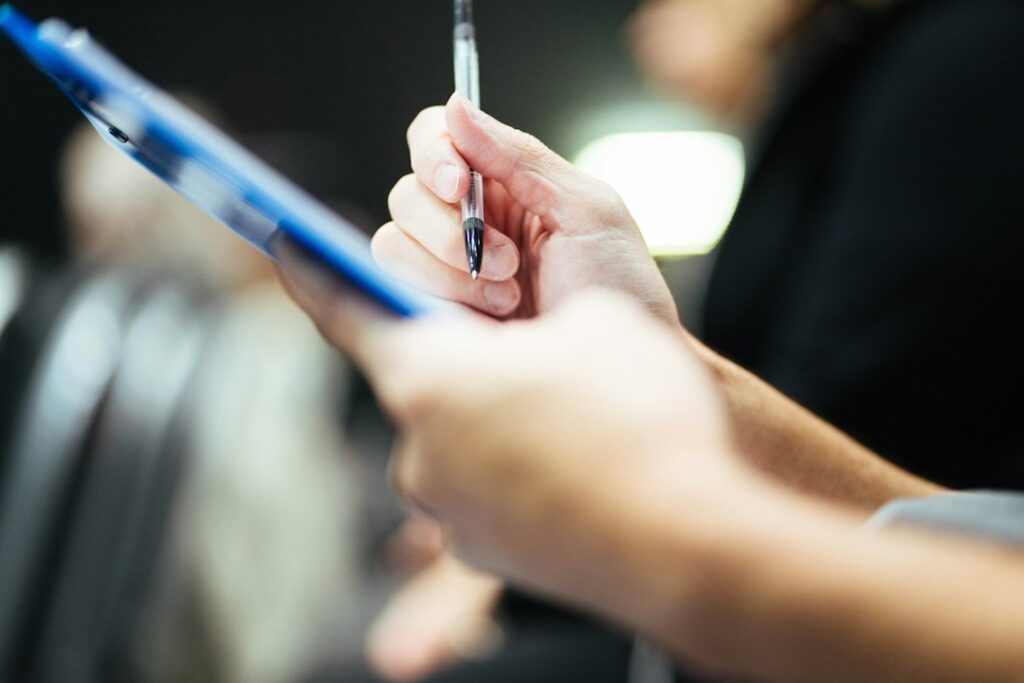 Hand mit Stift über einem Klemmbrett bei der Jahresplanung